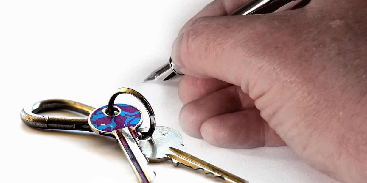 hand and keys hand holding a fountain pen and keys on the table
