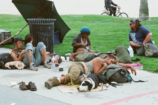 group of homeless people lounging on the pavement in venice california