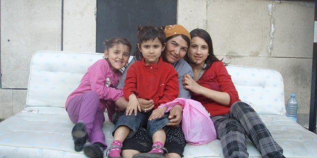 Mother and three children sitting on a mattress in Paris