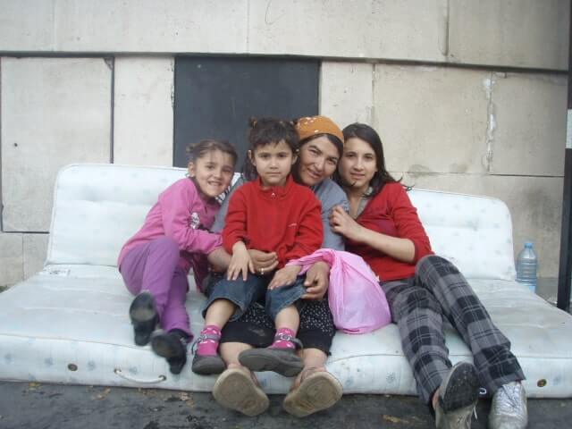 Mother and three children sitting on a mattress in Paris