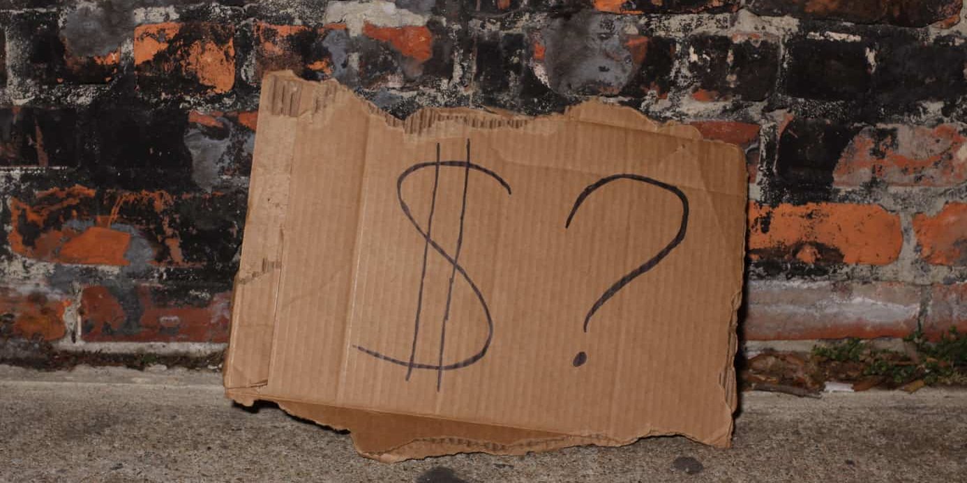 cardboard sign with a dollar and question mark symbols