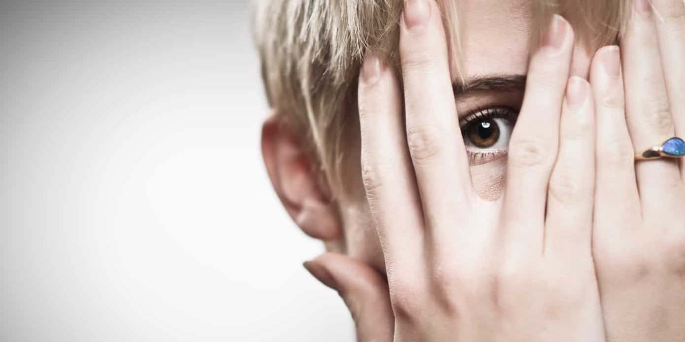 Beautiful Young Caucasian Woman Peeking Through Fingers caucasian woman covering her face in shame